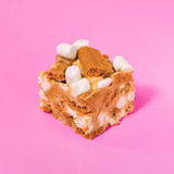 Biscoff Rocky Road square with marshmallows, Biscoff chunks, and white chocolate by Crumbs & Doilies on pink background